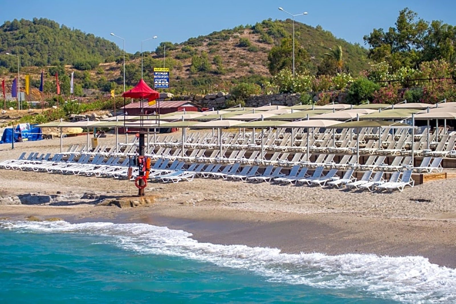 The beach with the lifeguard post and the hillside behind
