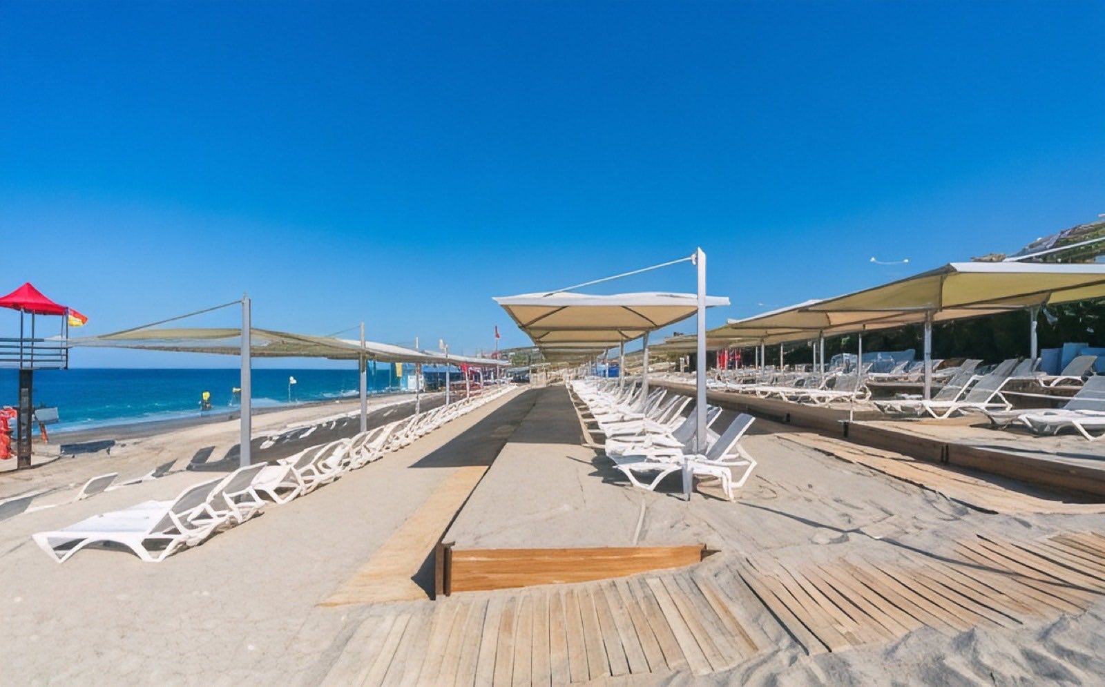 The walkway down the hotel's private beach, loungers and shades either side