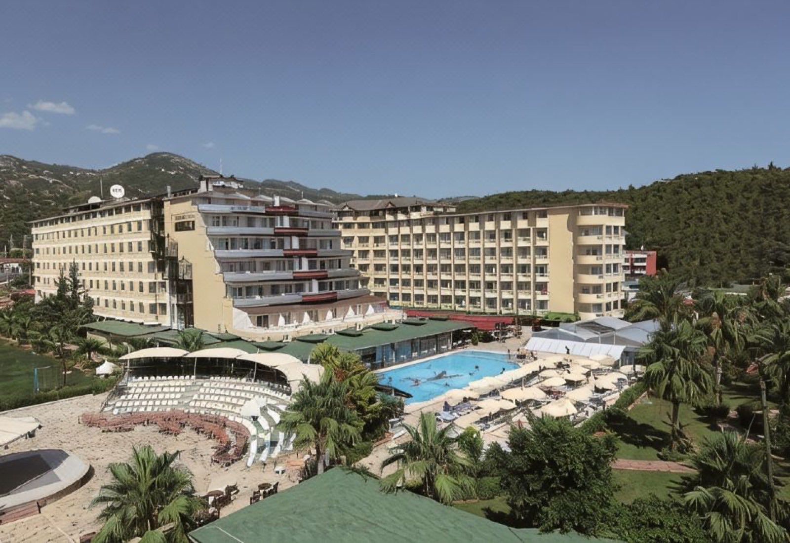 The hotel, its amphitheatre and pool seen from above, with the hills behind